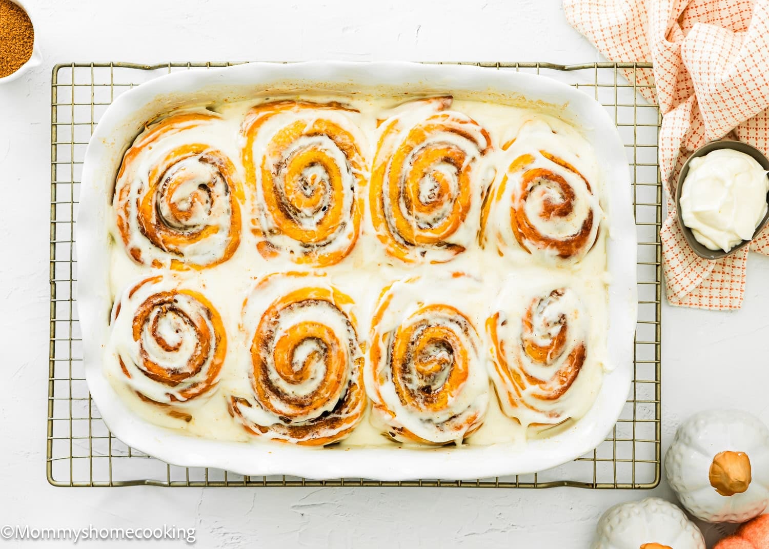 Iced Egg-free pumpkin cinnamon rolls in a baking dish.