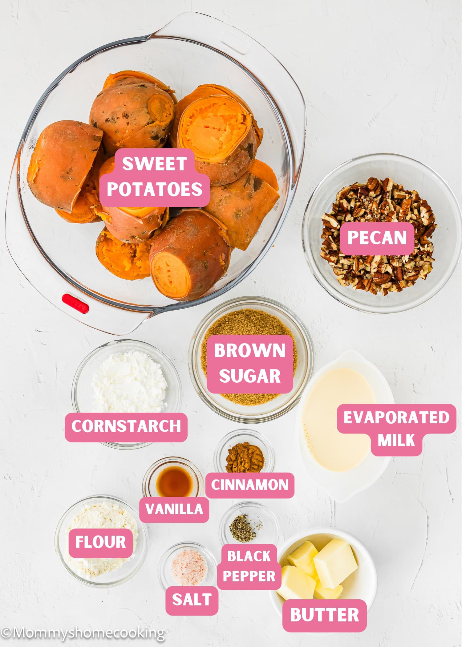 Top-down view of labeled ingredients for Eggless Sweet Potato Casserole, including sweet potatoes, pecans, brown sugar, evaporated milk, cornstarch, flour, vanilla, cinnamon, black pepper, salt, and butter.