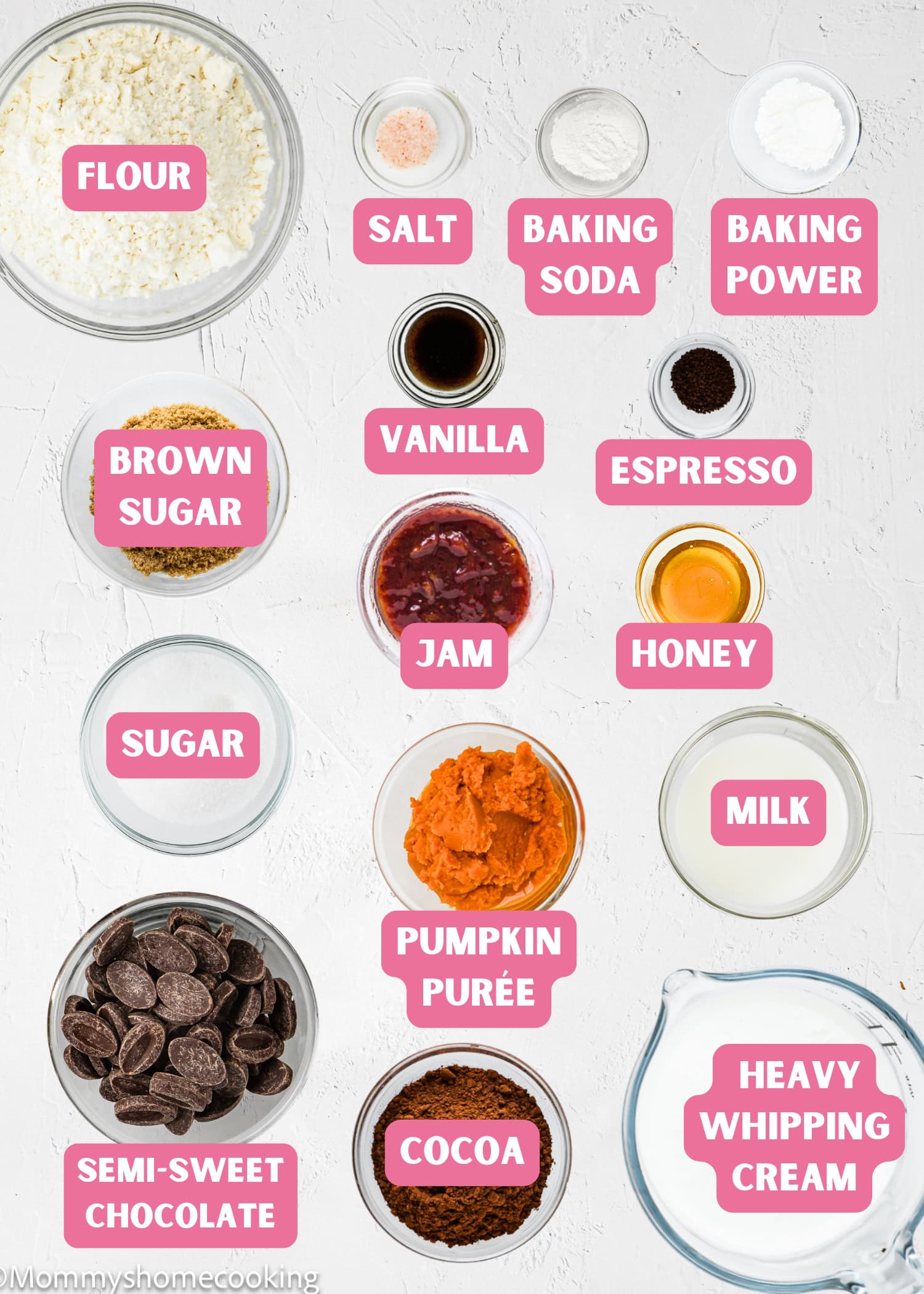 Various baking ingredients are arranged in bowls and labeled, including flour, sugars, pumpkin purée, chocolate, cocoa, honey, milk, and heavy cream—perfect essentials for creating an Eggless Yule Log (Bûche De Noël) or other festive treats.