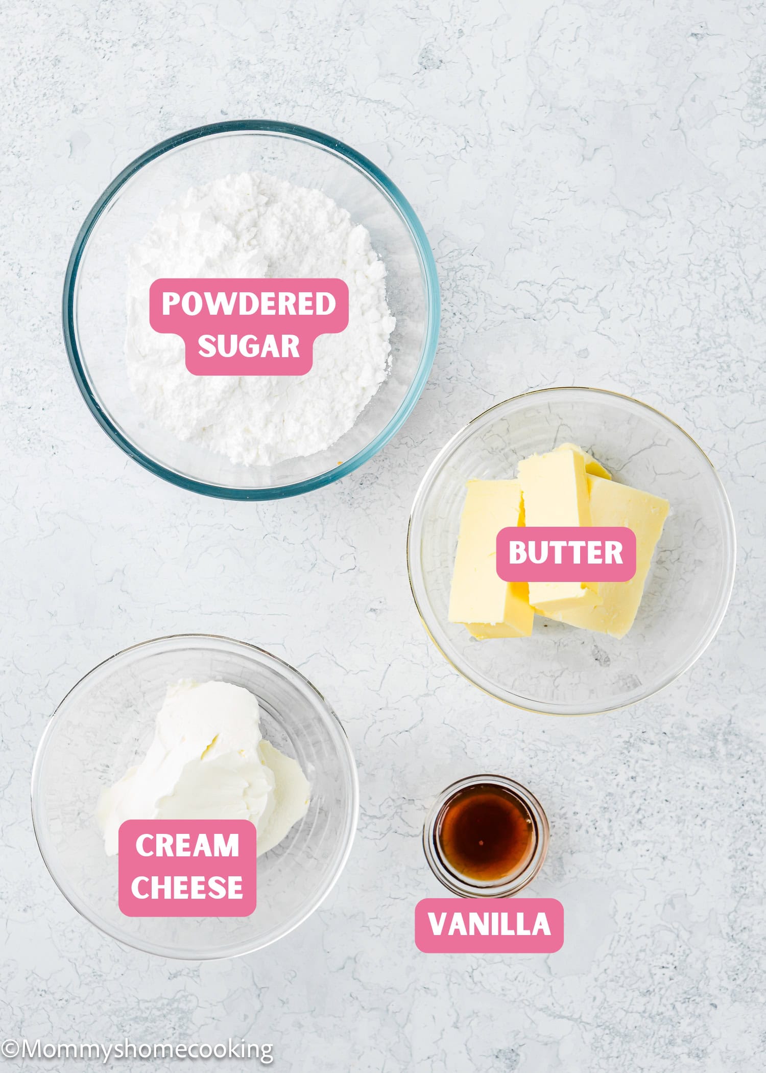 Four bowls containing labeled ingredients for an easy cream cheese glaze—powdered sugar, butter, cream cheese, and vanilla—are arranged on a light surface.