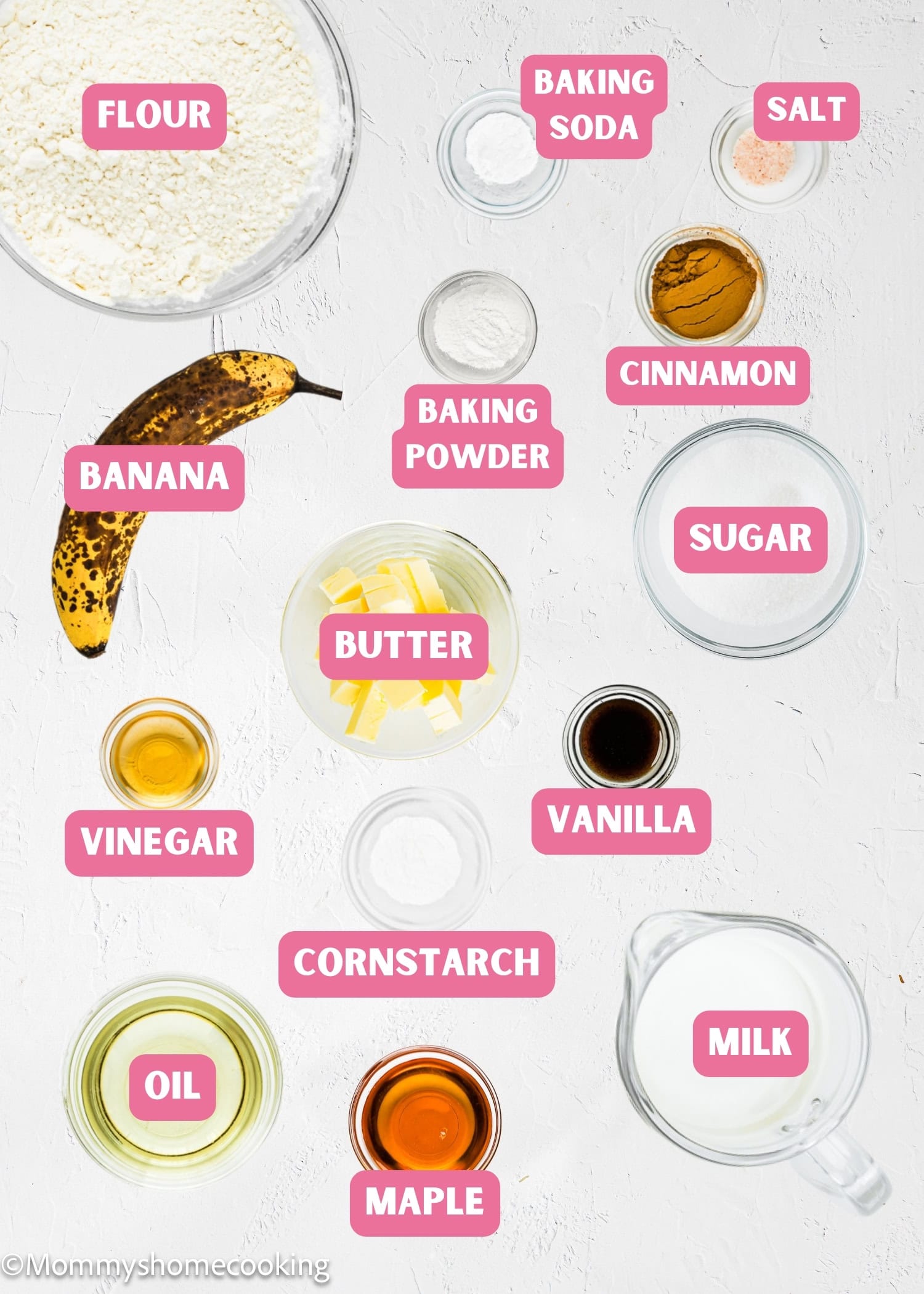 Top-down view of labeled baking ingredients for Eggless Banana Waffles, including flour, baking soda, salt, banana, baking powder, cinnamon, butter, sugar, vinegar, vanilla, cornstarch, maple syrup, oil, and milk.
