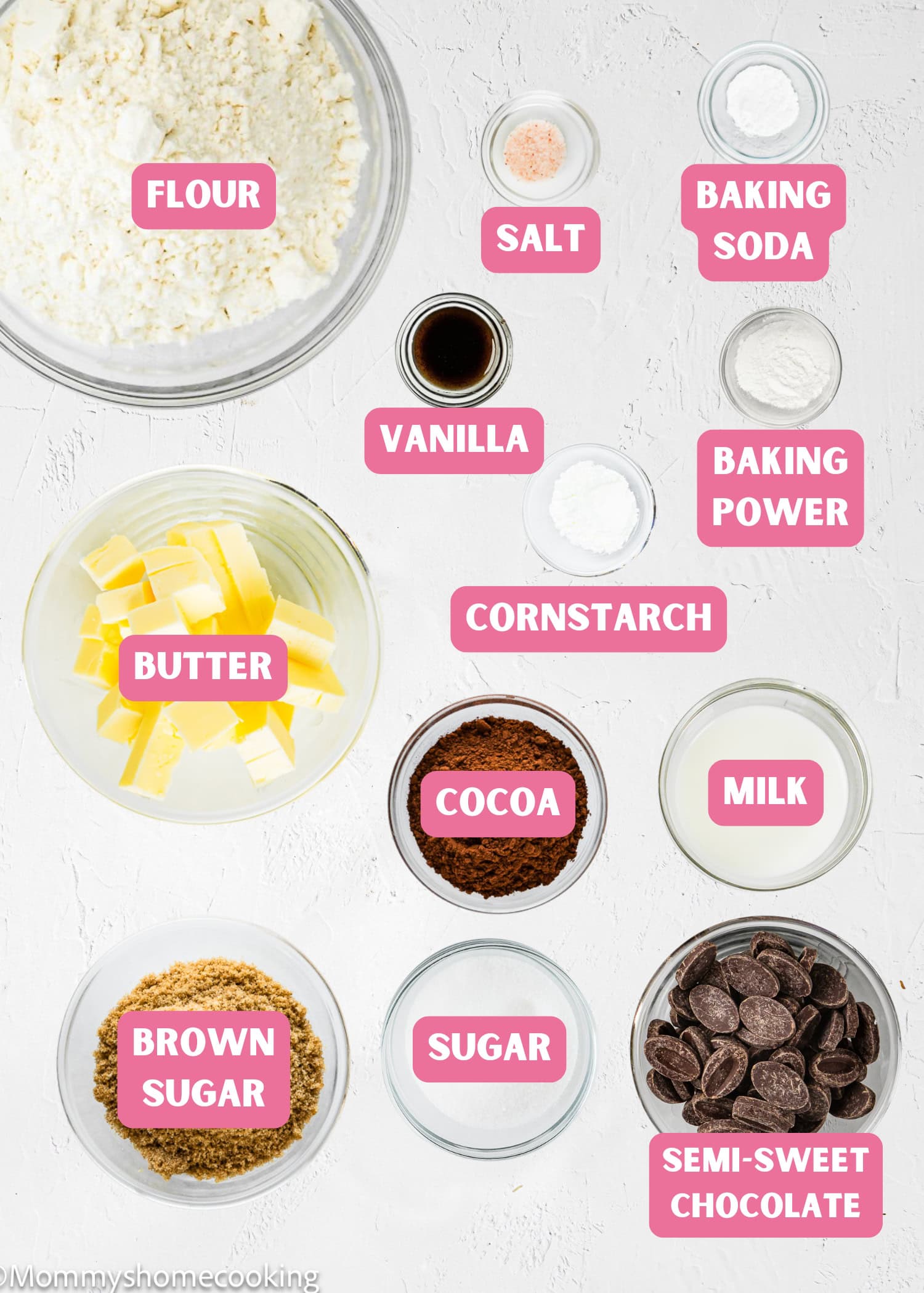 Top-down view of baking ingredients in bowls, labeled: flour, salt, baking soda, vanilla, baking powder, cornstarch, butter, cocoa, milk, sugars, and semi-sweet chocolate for Eggless Brookie Cookies (One Dough).