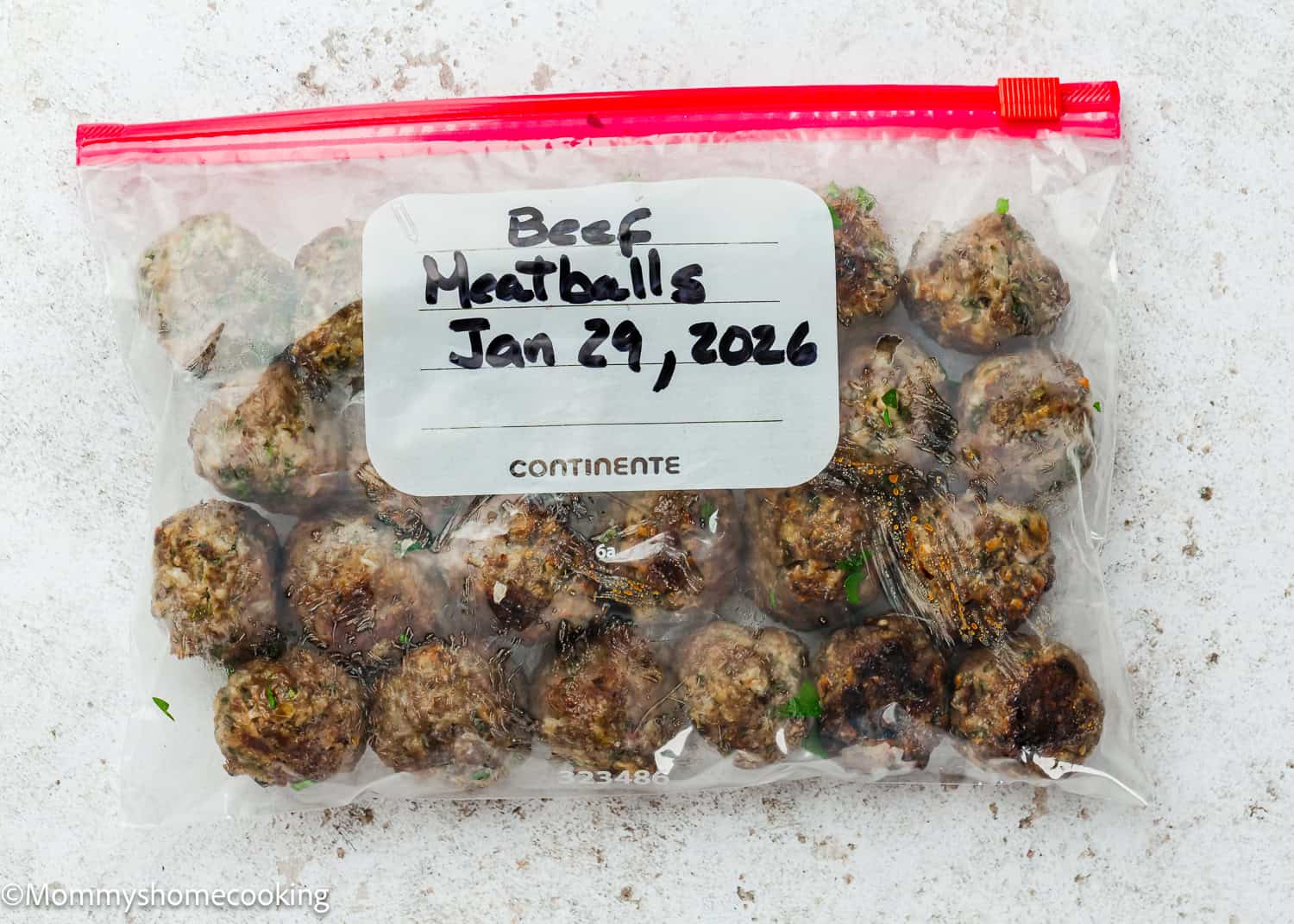 A clear plastic freezer bag labeled "Beef Meatballs Jan 29, 2026" contains several cooked meatballs made using a simple meatball recipe without eggs, shown on a white surface.