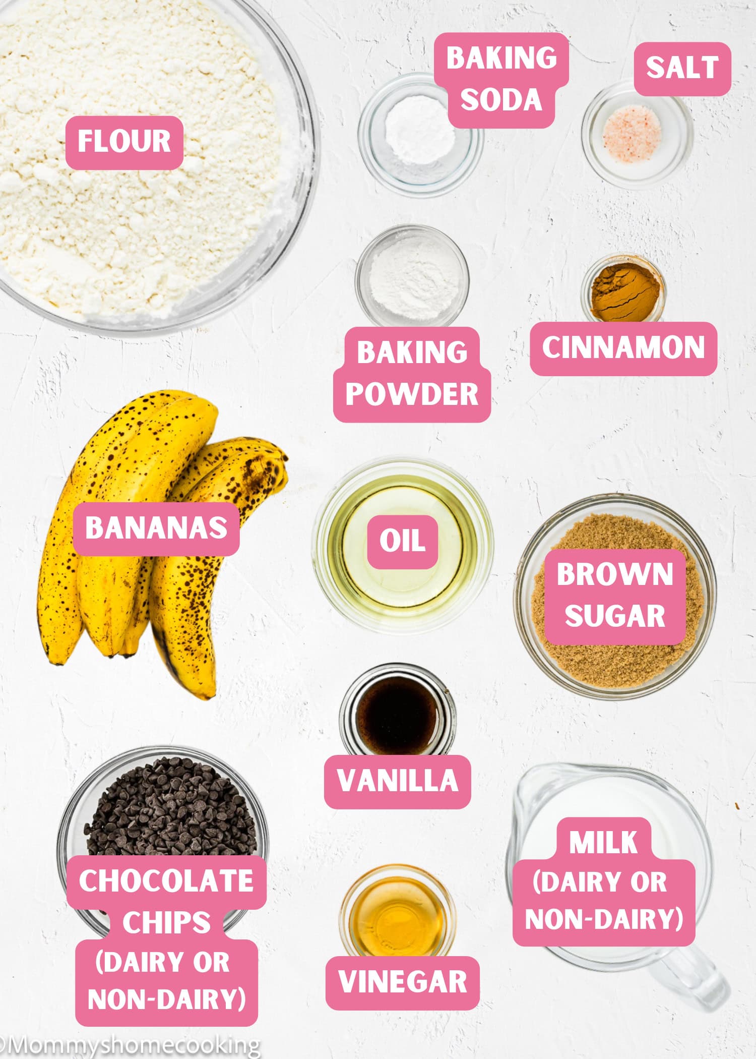 A flat lay of ingredients for Egg-Free & Dairy-Free Chocolate Chip Banana Bread (Easy + One Bowl), featuring flour, baking soda, salt, baking powder, cinnamon, bananas, oil, brown sugar, vanilla, chocolate chips, vinegar, and milk.