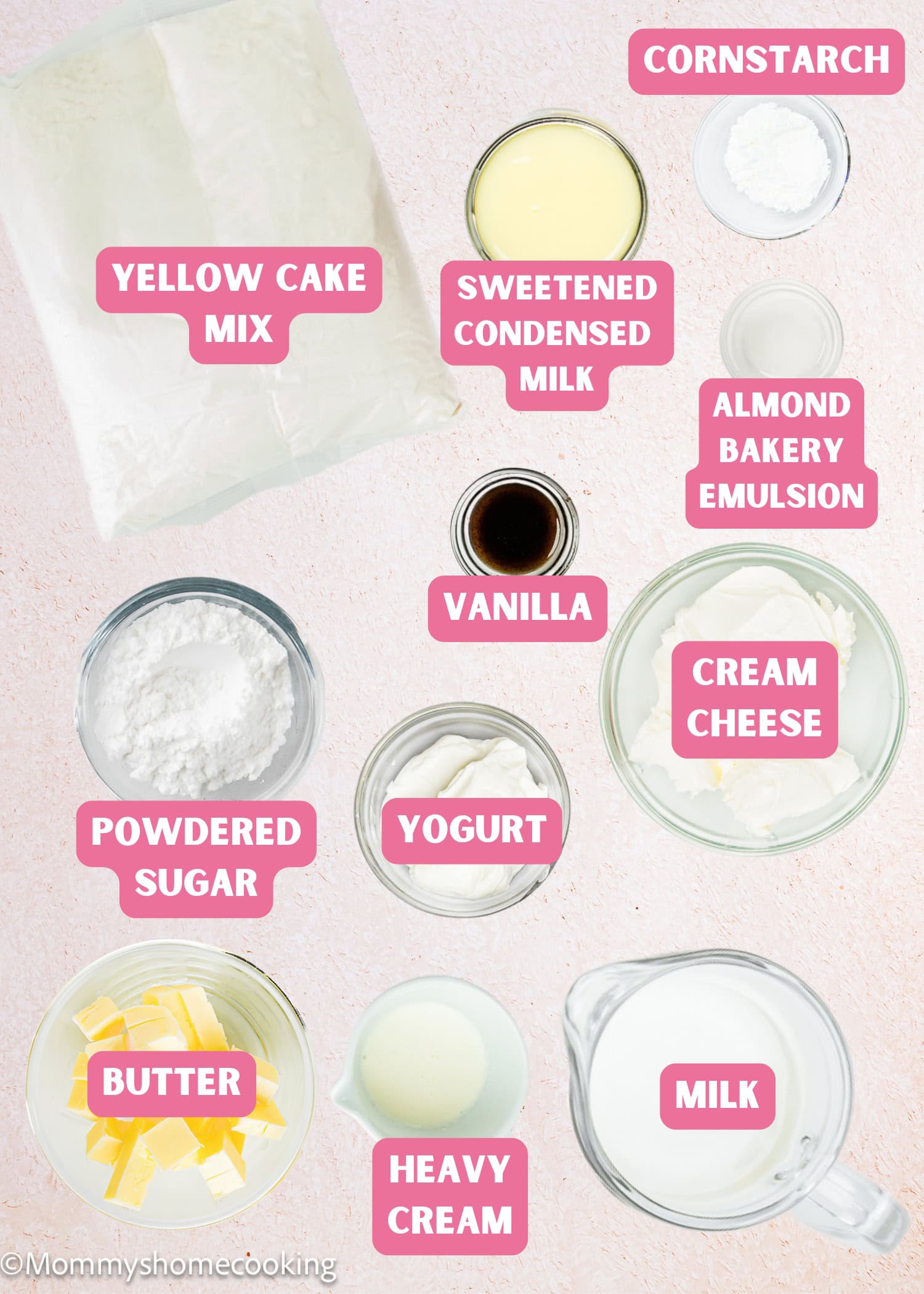 Top-down view of labeled baking ingredients for Eggless Ooey Gooey Butter Bars (Neiman Marcus Bars), including yellow cake mix, sweetened condensed milk, cornstarch, vanilla, almond bakery emulsion, cream cheese, yogurt, milk, butter, and powdered sugar.
